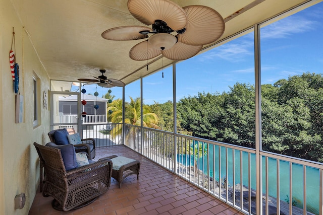 sunroom / solarium featuring a ceiling fan