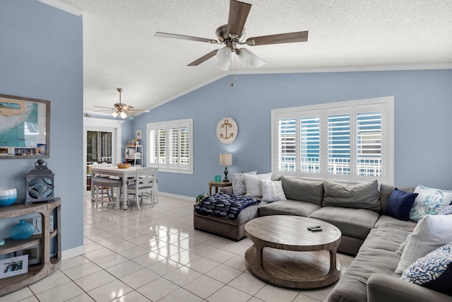 living room with light tile patterned floors, lofted ceiling, a ceiling fan, a textured ceiling, and baseboards