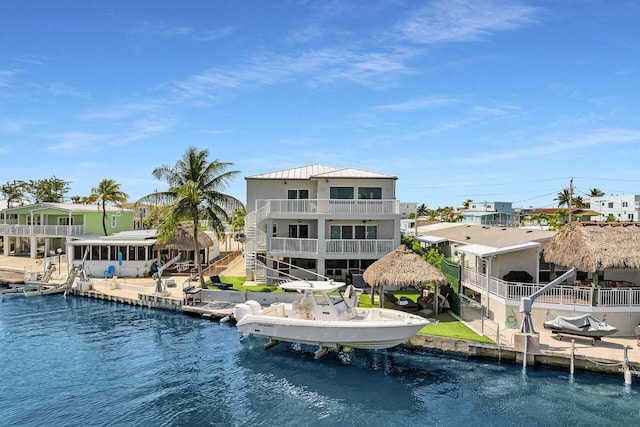 rear view of house featuring a water view, a community pool, and metal roof