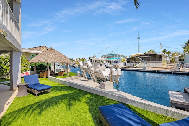 view of swimming pool featuring a yard, a boat dock, a water view, and boat lift