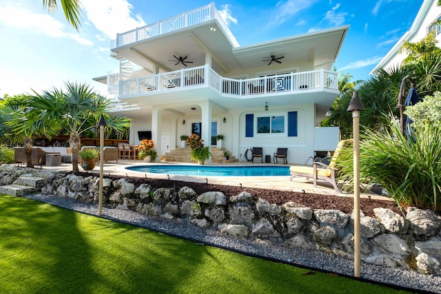 rear view of property with ceiling fan, a patio, and a balcony