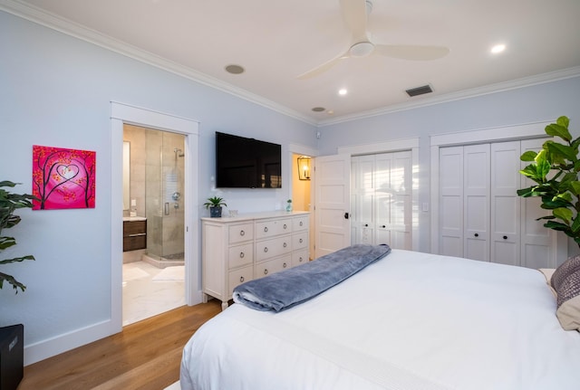 bedroom featuring crown molding, two closets, and light hardwood / wood-style floors