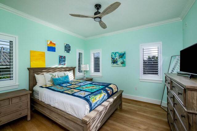 bedroom with crown molding, hardwood / wood-style floors, and ceiling fan