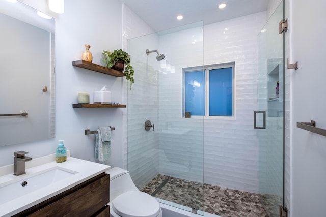 bathroom featuring vanity, an enclosed shower, and toilet