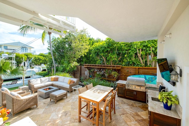 view of patio / terrace featuring an outdoor kitchen, area for grilling, and an outdoor living space with a fire pit