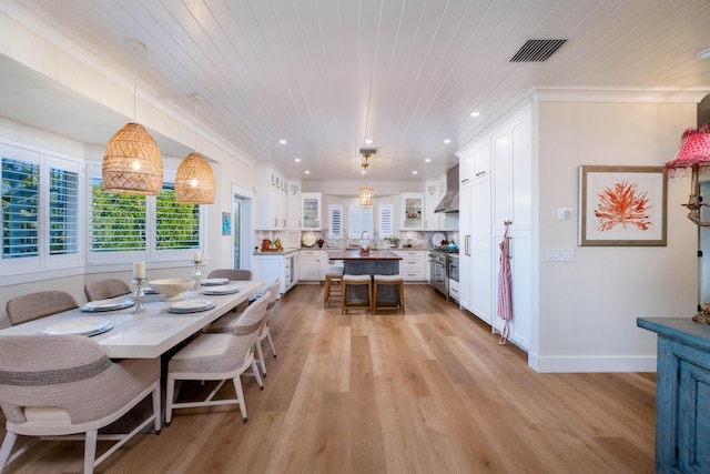 dining room featuring ornamental molding, wooden ceiling, and light hardwood / wood-style floors