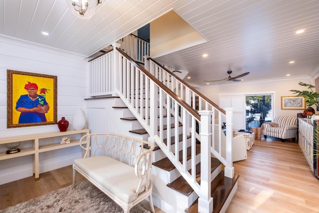 stairs featuring crown molding, hardwood / wood-style floors, wood ceiling, and ceiling fan