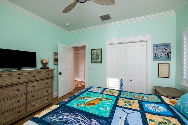 bedroom with crown molding, hardwood / wood-style floors, ceiling fan, and a closet