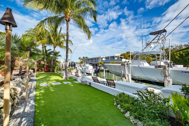 view of dock with a water view and a yard