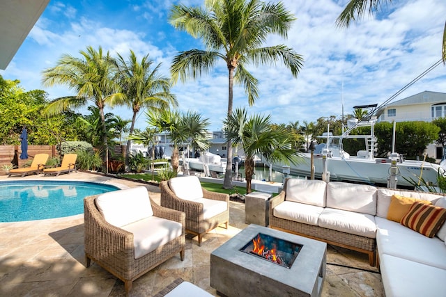 view of swimming pool featuring an outdoor living space with a fire pit and a patio