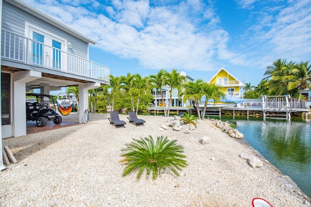 view of yard with a water view and a boat dock