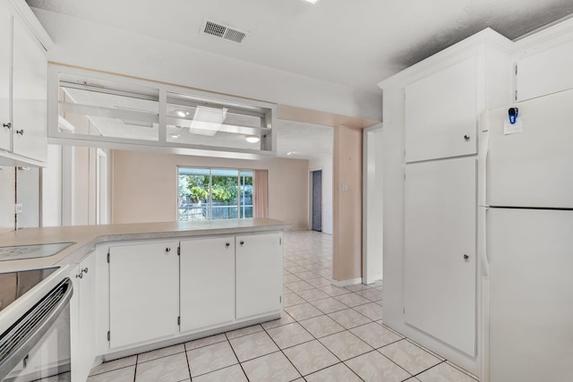 kitchen with electric stove, white cabinets, light tile patterned flooring, kitchen peninsula, and white fridge