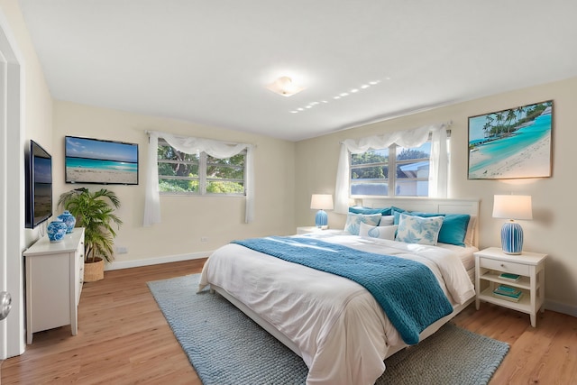 bedroom with multiple windows and light wood-type flooring