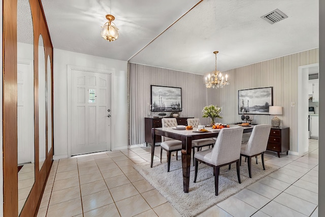 dining space featuring washer / clothes dryer, a chandelier, and light tile patterned flooring