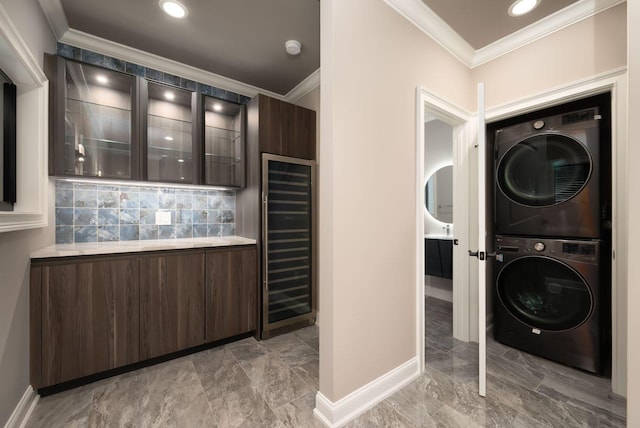 interior space featuring stacked washer / dryer, ornamental molding, and beverage cooler