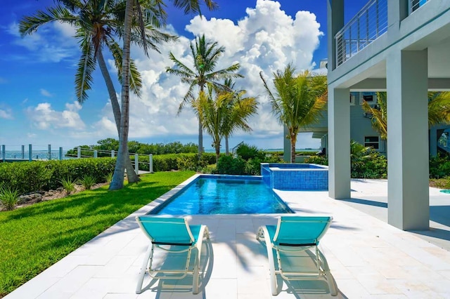 view of swimming pool featuring a patio area, a lawn, and an in ground hot tub