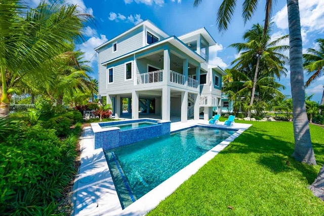 view of pool with a patio area, a lawn, and an in ground hot tub