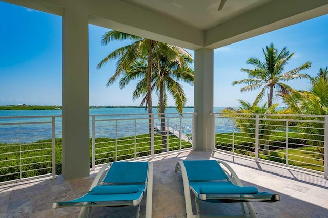 view of patio featuring a balcony and a water view