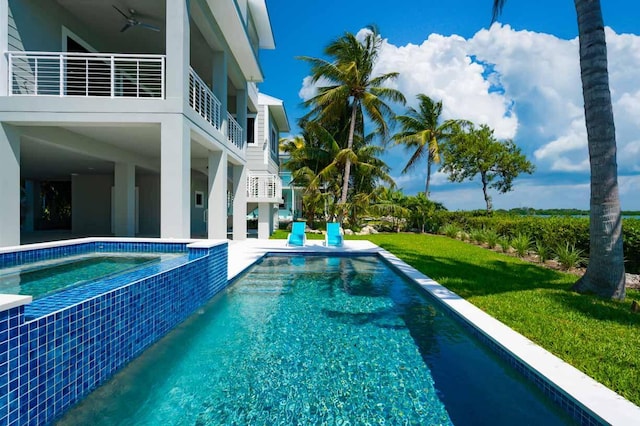 view of swimming pool with a lawn and ceiling fan