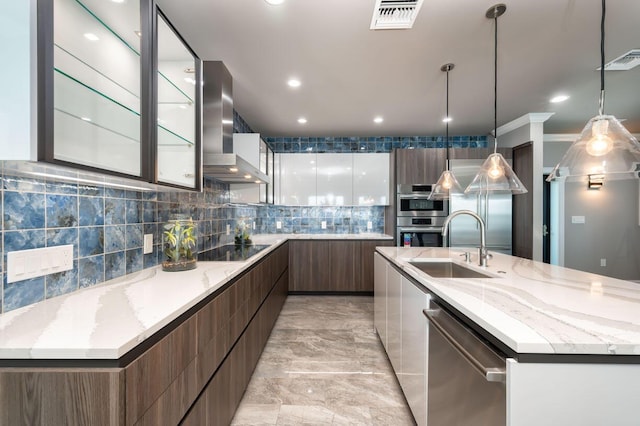 kitchen with a large island, pendant lighting, stainless steel appliances, white cabinets, and wall chimney exhaust hood