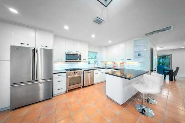 kitchen with stainless steel appliances, dark countertops, and visible vents