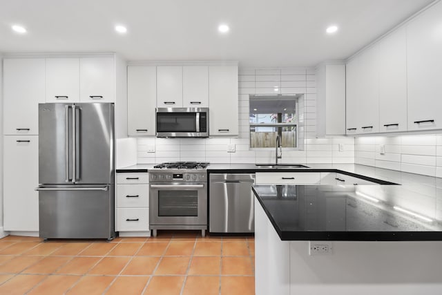 kitchen with sink, white cabinetry, light tile patterned floors, appliances with stainless steel finishes, and decorative backsplash