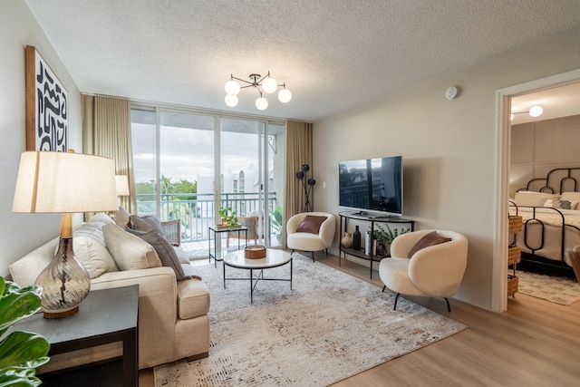 living room featuring expansive windows, a textured ceiling, and light hardwood / wood-style flooring