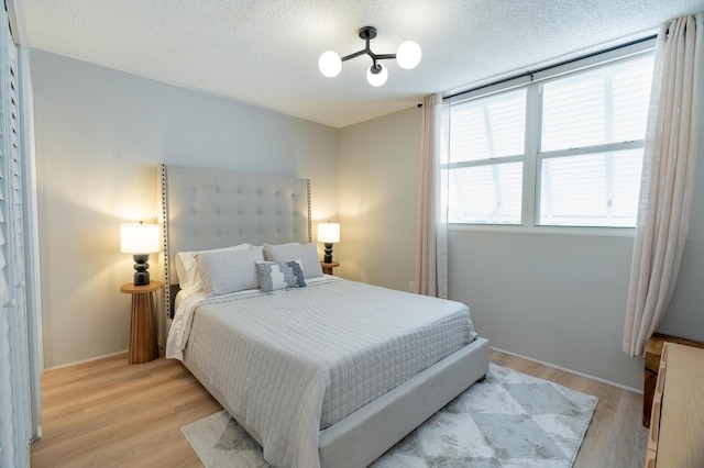 bedroom featuring a textured ceiling and light wood-type flooring