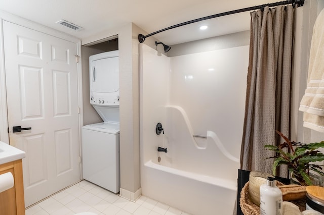 bathroom featuring tile patterned floors, stacked washer / drying machine, shower / tub combo, and vanity