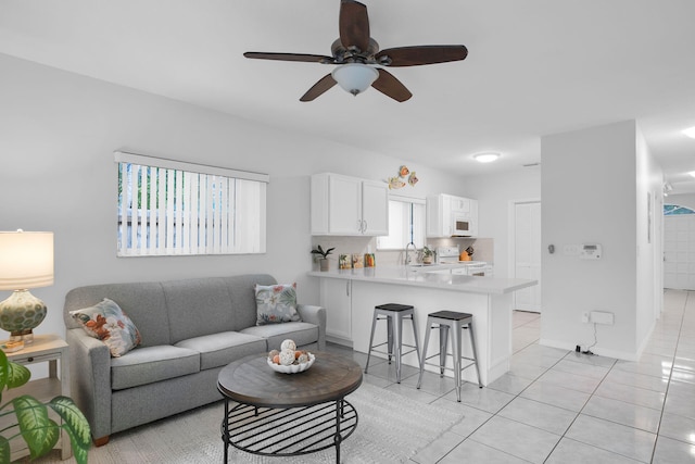 living room featuring ceiling fan and light tile patterned floors