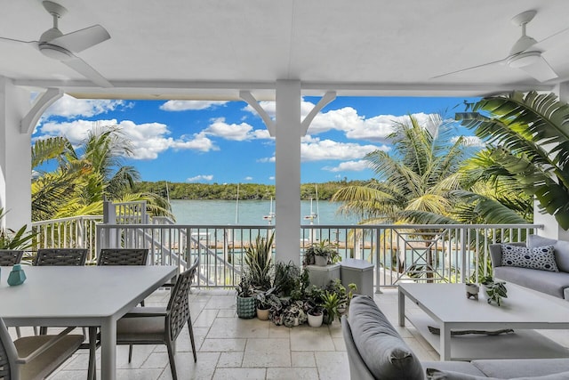 balcony featuring a water view, outdoor dining area, an outdoor living space, and a ceiling fan