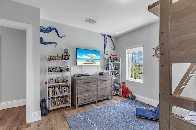 rec room featuring light wood-style flooring, visible vents, and baseboards