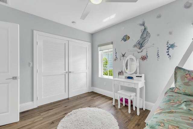 bedroom with a ceiling fan, a closet, baseboards, and wood finished floors