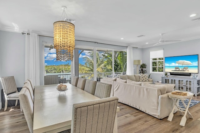 dining area featuring light wood finished floors, visible vents, ornamental molding, and recessed lighting