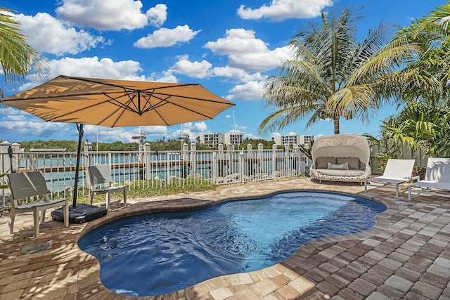 view of pool featuring a water view, a patio area, fence, and a fenced in pool