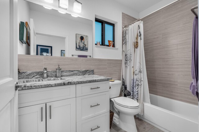 full bathroom featuring vanity, toilet, tile walls, and shower / bathtub combination with curtain