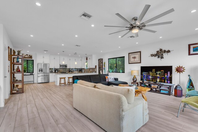 living room with ceiling fan and light hardwood / wood-style floors