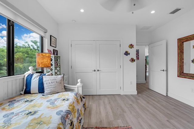 bedroom with ceiling fan, a closet, and light hardwood / wood-style flooring