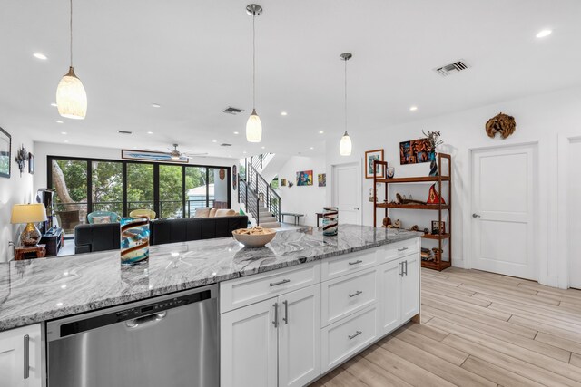 kitchen featuring stainless steel dishwasher, hanging light fixtures, and white cabinets