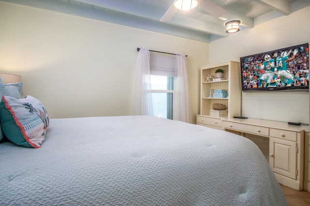 bedroom with beam ceiling and light tile patterned floors