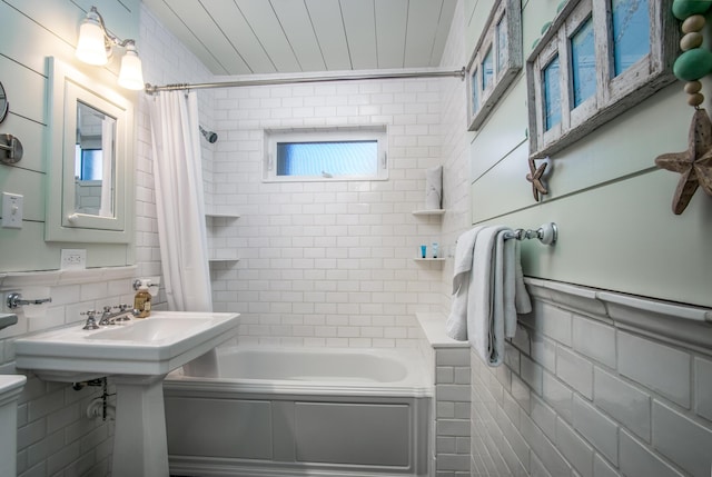 bathroom featuring tile walls and shower / bath combo with shower curtain