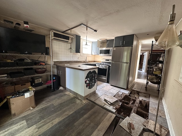 1014 Varela St Unit 3, Key West, FL 33040 - kitchen featuring backsplash, a wall unit AC, appliances with stainless steel finishes, a textured ceiling, and a peninsula