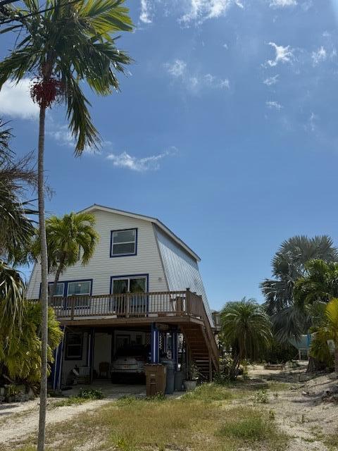 back of property with a wooden deck and stairs