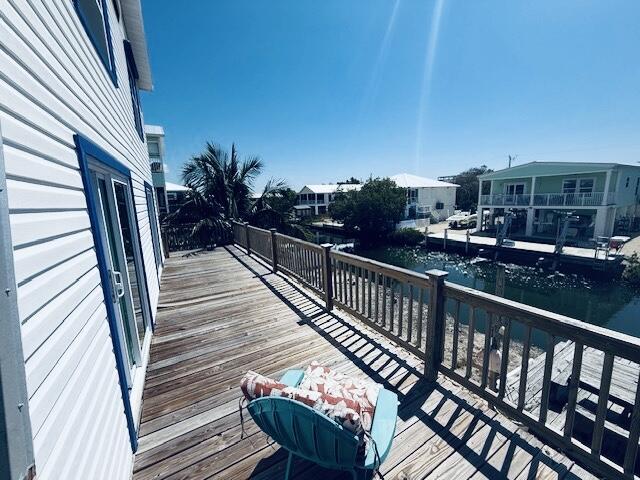 wooden deck featuring a water view and a residential view