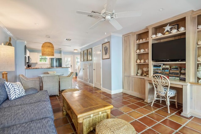 tiled living room with crown molding, built in desk, built in features, and ceiling fan