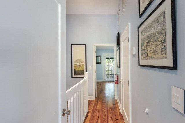 corridor with hardwood / wood-style flooring