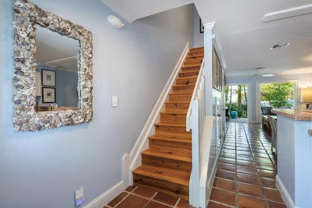 stairs featuring tile patterned floors and ceiling fan