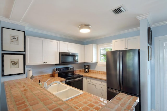 kitchen featuring sink, refrigerator, tile counters, black range with electric stovetop, and white cabinets