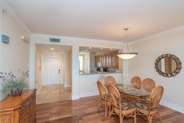 dining area with dark hardwood / wood-style flooring, crown molding, and a textured ceiling