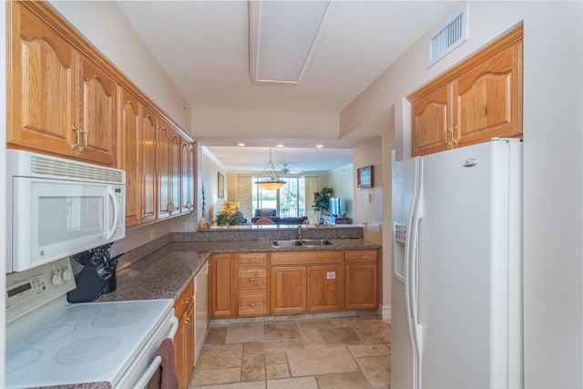 kitchen featuring white appliances, sink, and hanging light fixtures